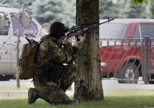A pro-Russian rebel aims his rifle towards the local administration building in Donetsk